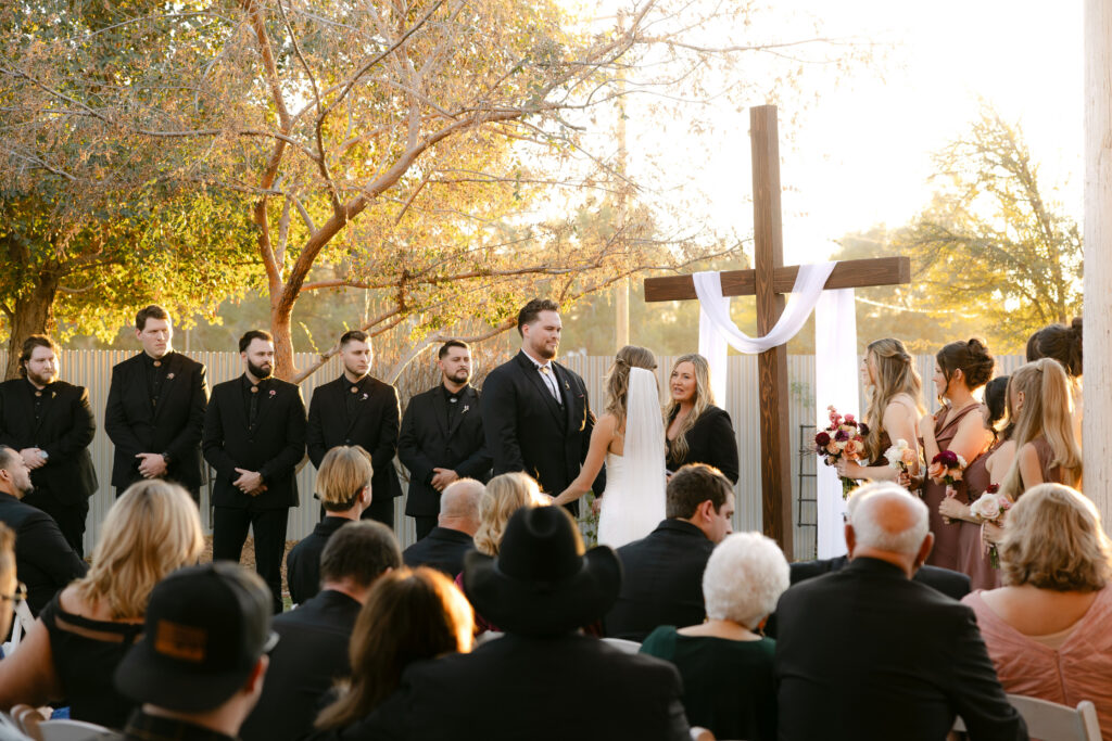 Outdoor wedding ceremony at Schnepf Farms Big Red Barn in Queen Creek Arizona during sunset