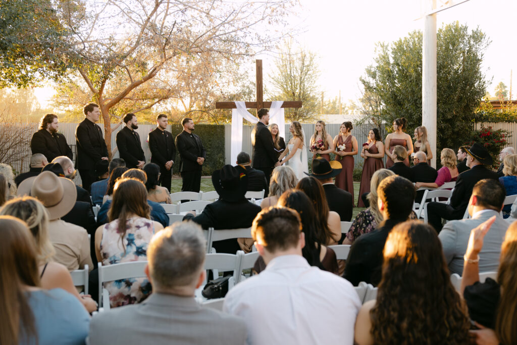 Outdoor wedding ceremony at Schnepf Farms Big Red Barn in Queen Creek Arizona during sunset