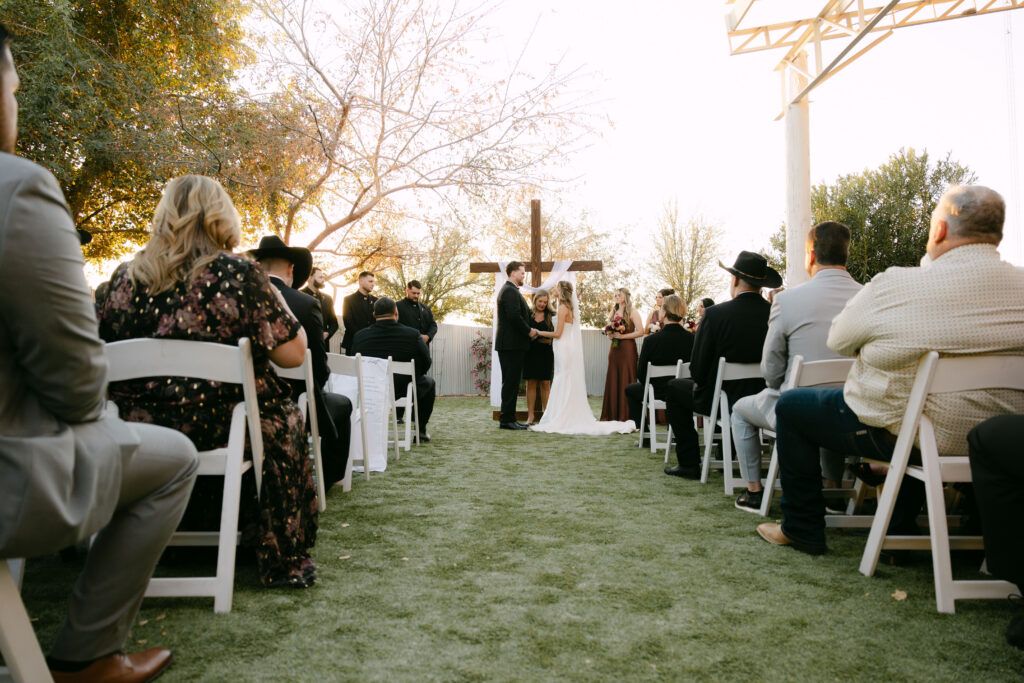Outdoor wedding ceremony at Schnepf Farms Big Red Barn in Queen Creek Arizona during sunset