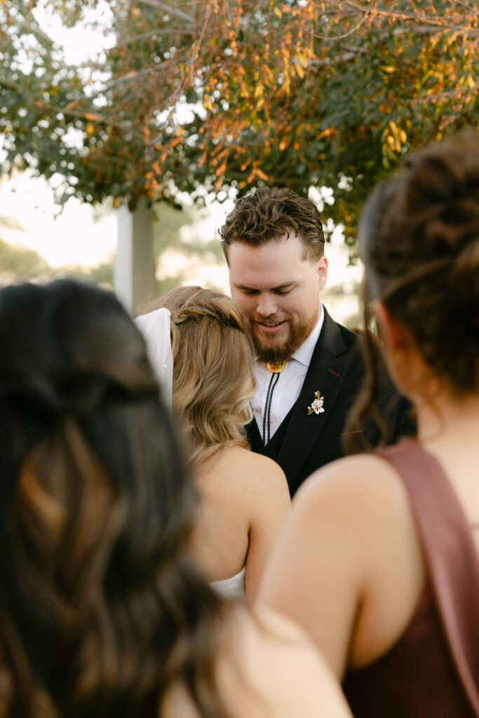 Outdoor wedding ceremony at Schnepf Farms Big Red Barn in Queen Creek Arizona during sunset
