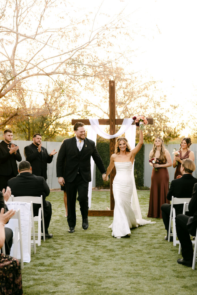 Outdoor wedding ceremony at Schnepf Farms Big Red Barn in Queen Creek Arizona during sunset