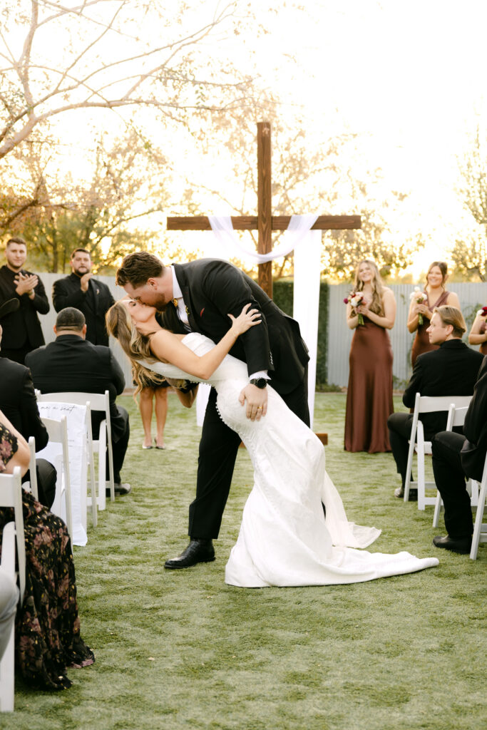 Outdoor wedding ceremony at Schnepf Farms Big Red Barn in Queen Creek Arizona during sunset