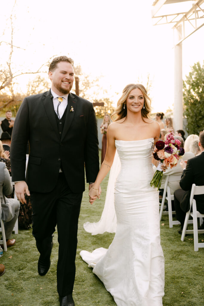 Outdoor wedding ceremony at Schnepf Farms Big Red Barn in Queen Creek Arizona during sunset