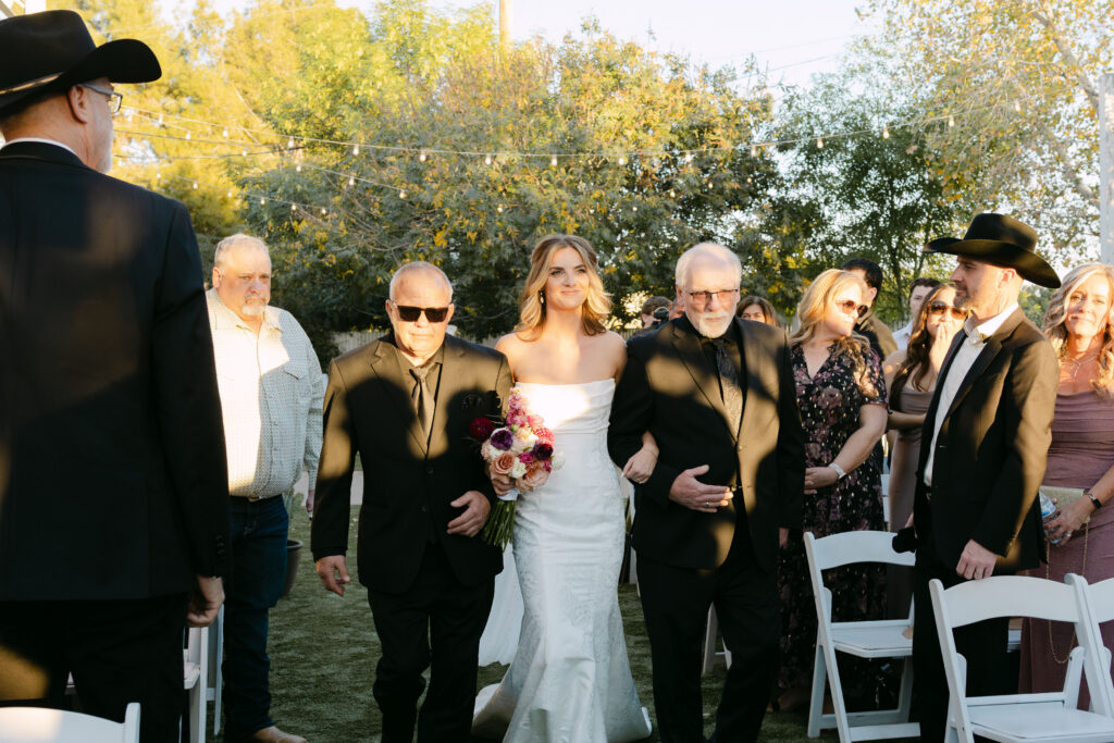 Outdoor wedding ceremony at Schnepf Farms Big Red Barn in Queen Creek Arizona during sunset